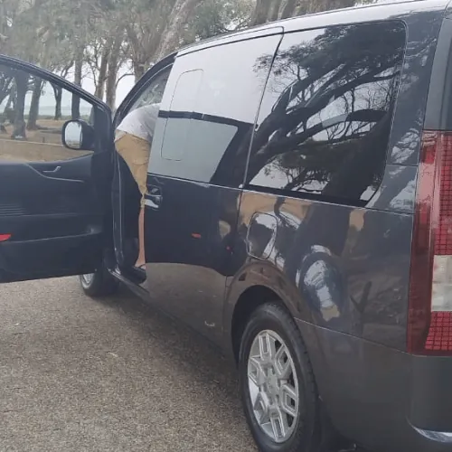 The side of the grey Staria with a door open